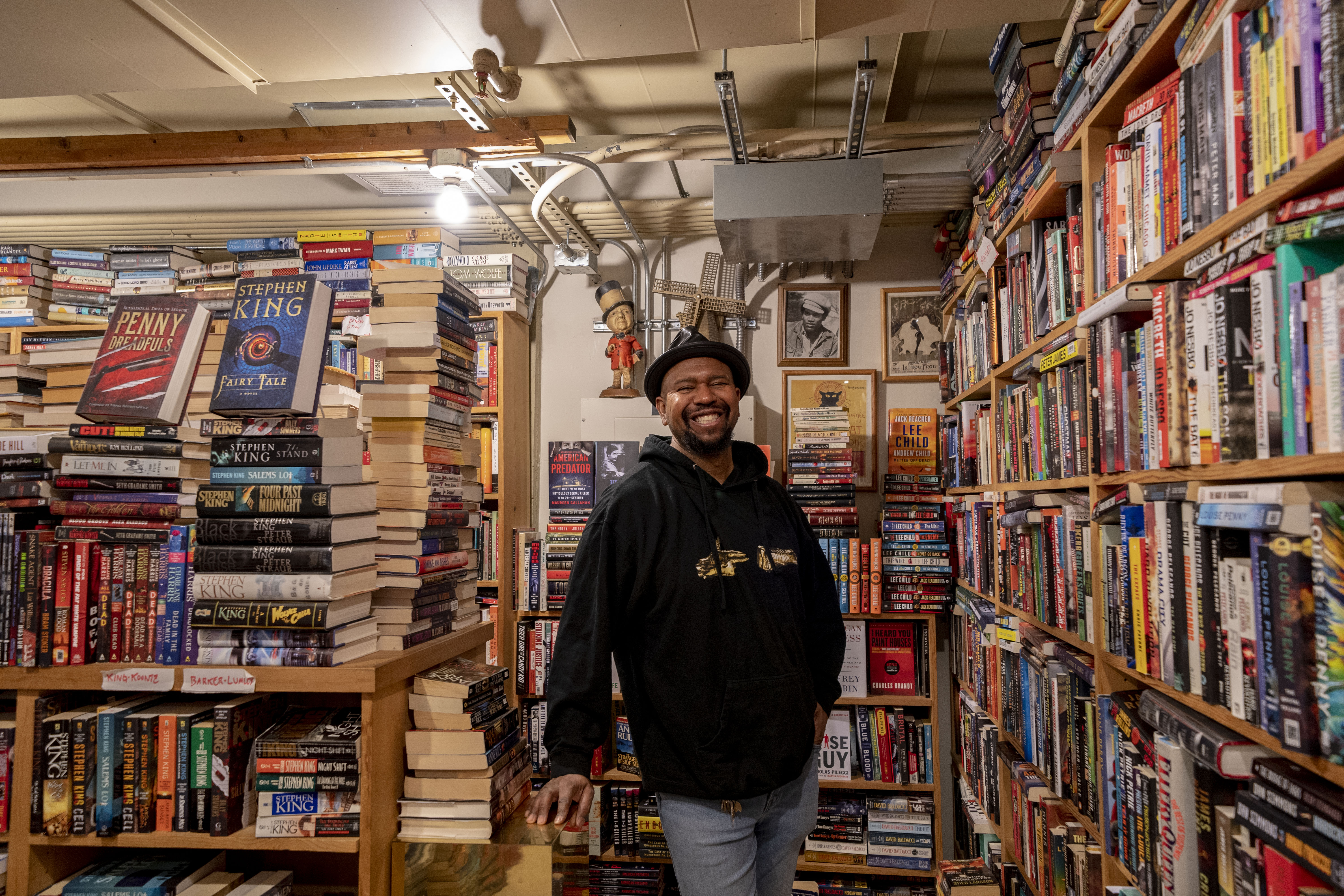 J.B. Johnson smiling inside his book store BLMF Literary Saloon in Pike Place Market.