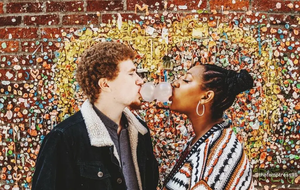 Couple kissing in front of the Gum Wall in Pike Place Market