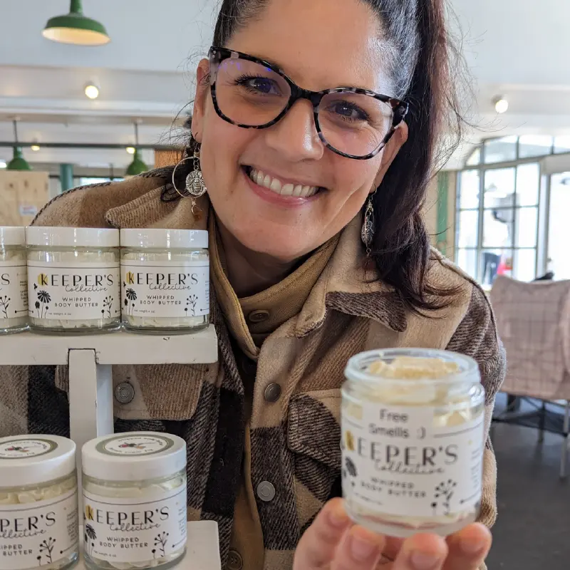 beekeeper jillian from keeper's collective showing off her whipped body butter. Keeper's collective is a vendor at pike place market