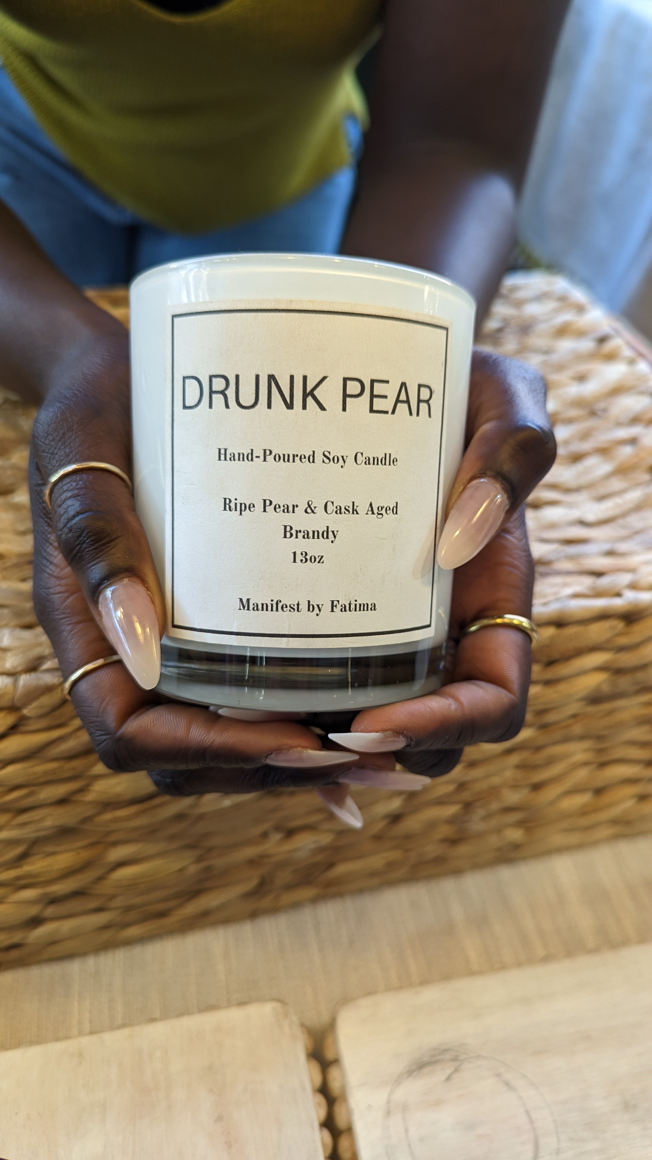 hands holding a soy wax candle scent drunk pear