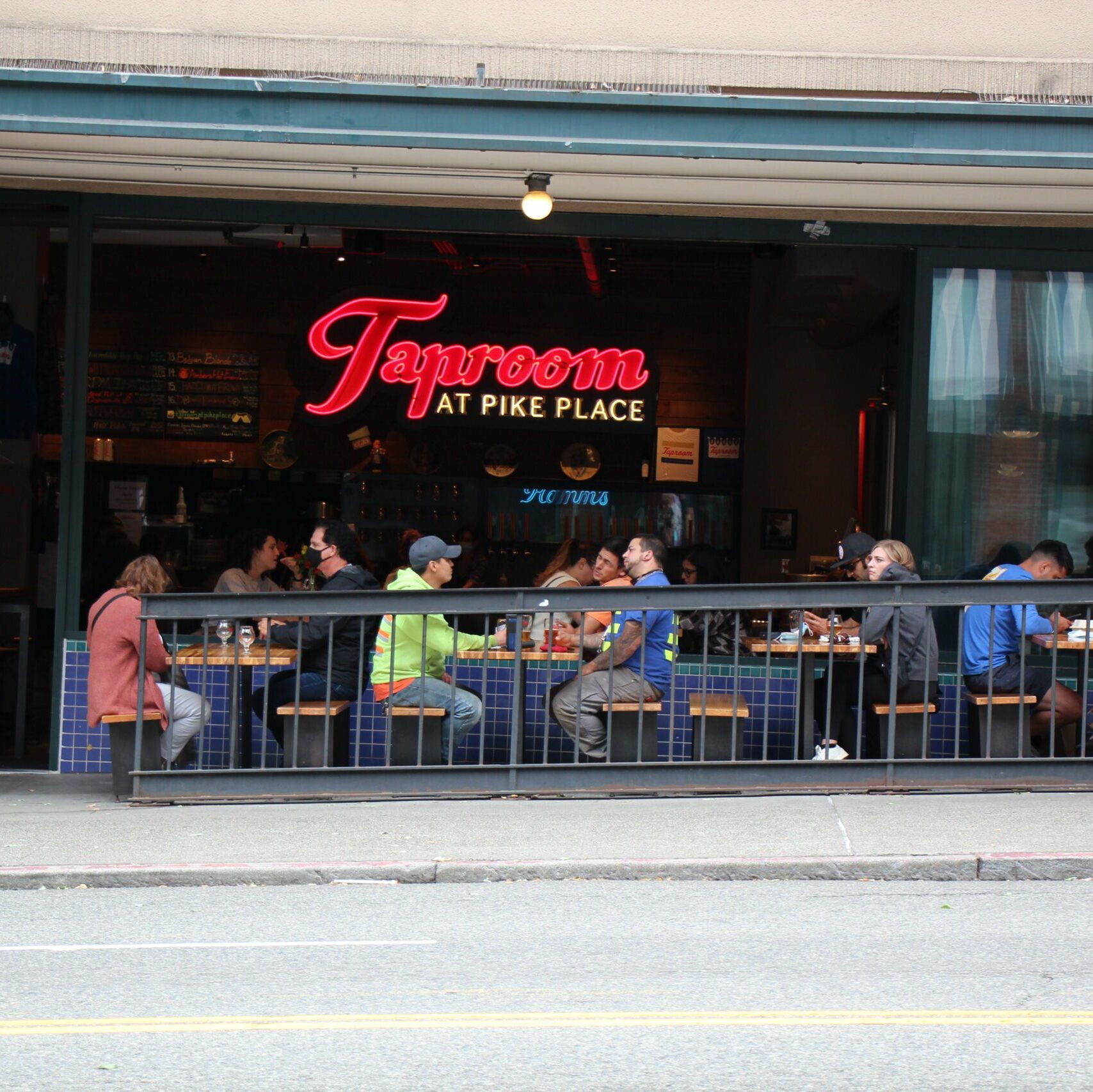 people sitting in a patio along 1st avenue in Seattle's pike place market