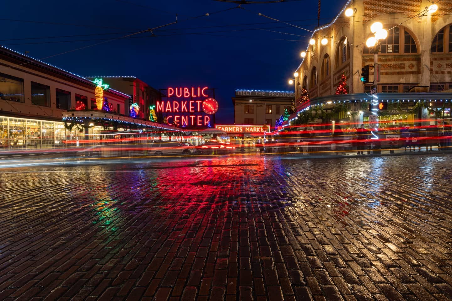 a photo of pike place market at night with holiday lights
