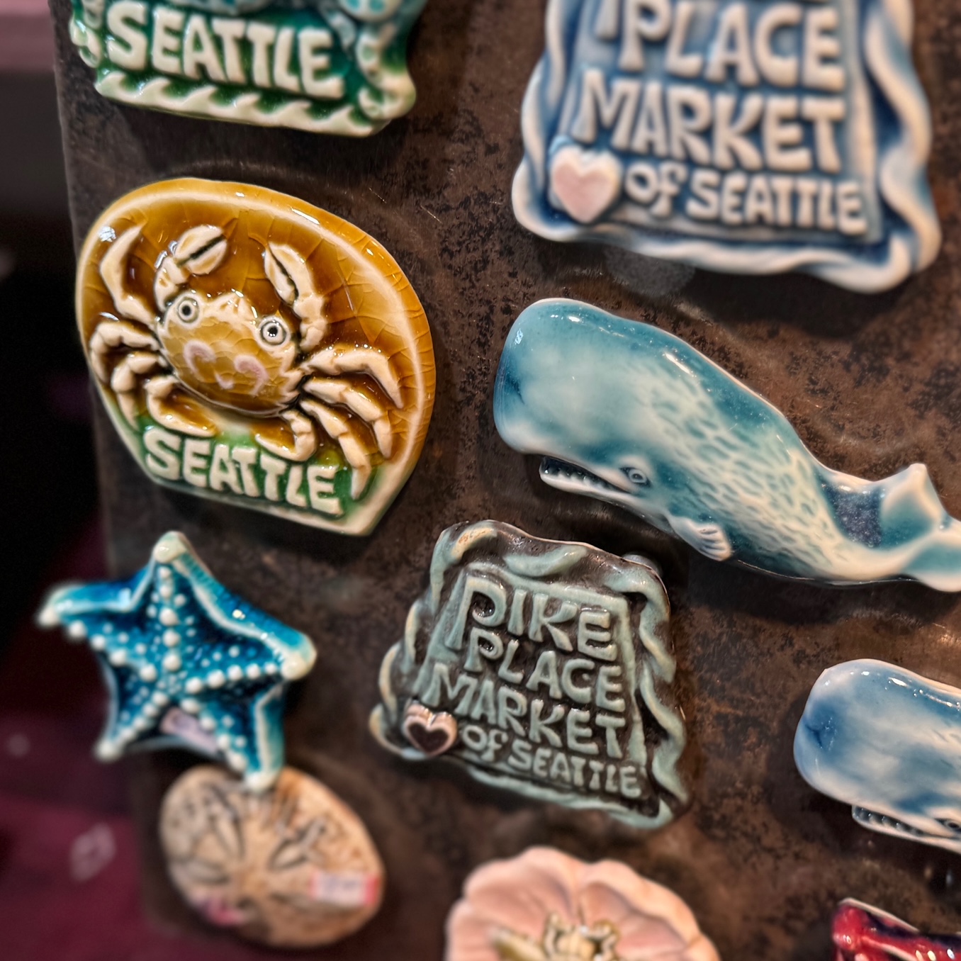 several pike place market and pacific northwest inspired clay magnets by Dark Duck Clay Shop in Pike Place Market